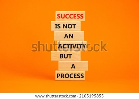 Success in process symbol. Wooden blocks with words Success is not an activity but a process. Beautiful orange table, orange background, copy space. Business, success in process concept.