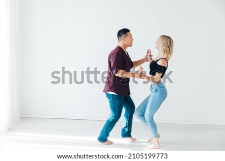 a woman and a man dancing to the music of a bachata Royalty-Free Stock Photo #2105199773