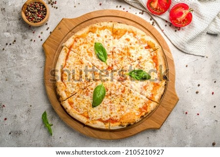 Italian pizza Margherita with cheese, tomato sauce and basil on grey concrete table top view Royalty-Free Stock Photo #2105210927