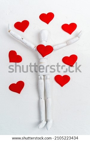 Wooden man mannequin on white background with red heart. Valentines Day or International Day of Charity. Flat lay. Vertical photo