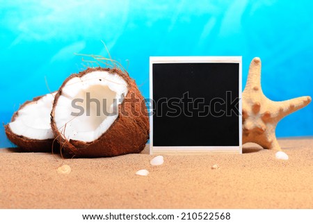 chopped coconut and photoframe on the sand. studio shot