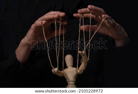 Hands manipulating wood puppet. Master of marionette. Royalty-Free Stock Photo #2105228972