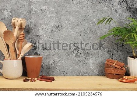 Empty rustic table with wooden appliances, utensils and palm leaves. Kitchen interior, mockup for design and product showcase, zero waste concept,