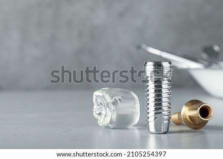 Parts of dental implant on grey table. Space for text Royalty-Free Stock Photo #2105254397