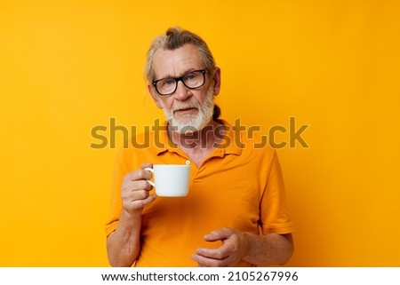 Portrait of happy senior man with a white mug of drink cropped view