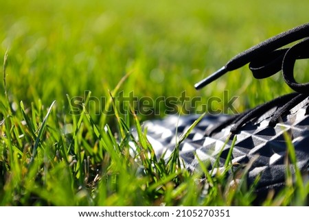 Close-up Picture of a Black Soccer Shoe on a Green Soccer Pitch