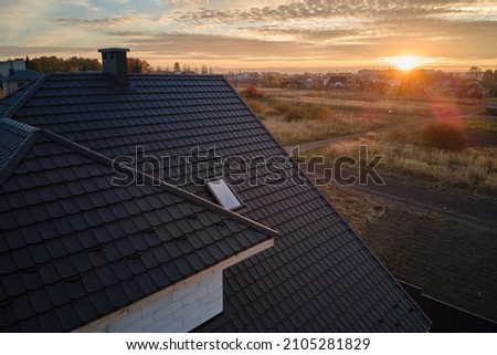 Closeup of house roof top covered with ceramic shingles. Tiled covering of building Royalty-Free Stock Photo #2105281829