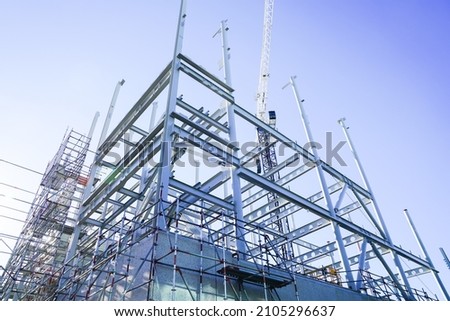 Steel framing and beams structural elements for new building against blue sky from low point of view. Royalty-Free Stock Photo #2105296637