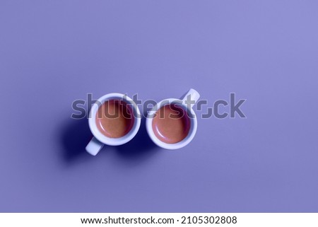 Two cups of coffee espresso top view on a very peri trendy color 2022 background