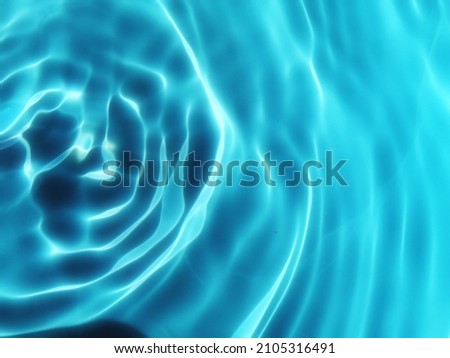 Closeup​ blur​ abstract​ of​ surface​ blue​ water​ for​ graphic​ design. Reflection​ on​ surface​ blue​ water​ in​ swimming​ pool for background.