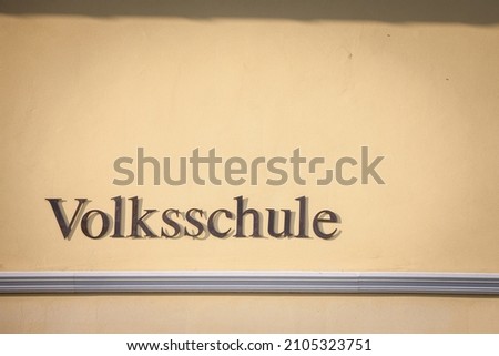 Sign indicating Volksschule, meaning in german People's school, on a building in Austria. Volksschule in Germany, Austria and Switzerland englobes primary and secondary school levels for students 