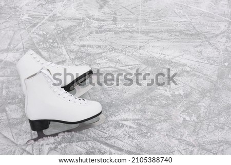 Pair of figure skates on ice, above view. Space for text