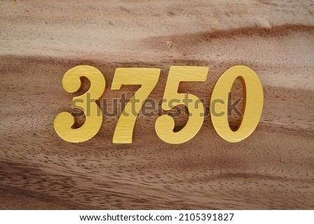 Golden Arabic numerals 3750 on a dark brown to white wood grain background.
