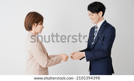 Businessman and businesswoman exchanging business cards. Royalty-Free Stock Photo #2105394398