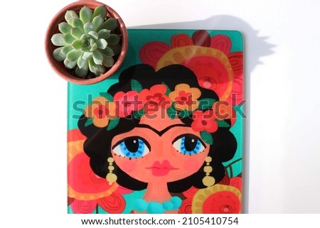 photograph of succulent plant on glass cutting board with the famous author pattern