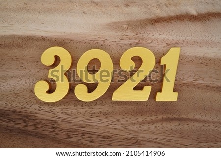 Golden Arabic numerals 3921 on a dark brown to white wood grain background.