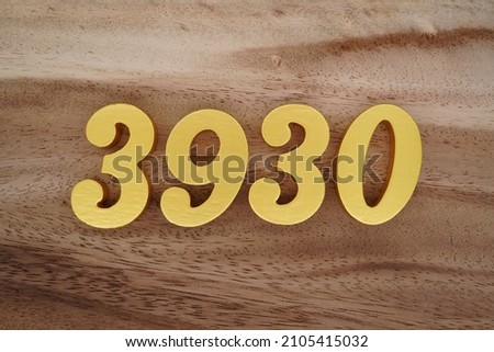 Golden Arabic numerals 3930 on a dark brown to white wood grain background.