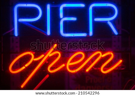 A blue and red Pier Open sign at the entrance of a public Pier in Belgium