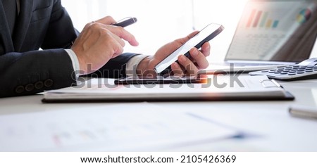 Businessman working at office with document, doing planning analyzing the financial report, business plan investment, finance analysis concept.Using smartphone and tablet.