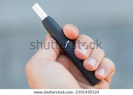 Picture of a man's hand holding an electric cigarette