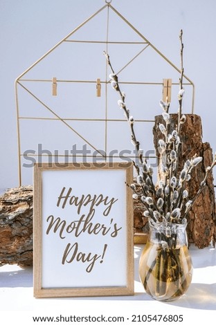 Happy mothers day lettering Mock up interior Picture frame with Willow branch in glass vase. Brunch of the blossoming pussywillow on early spring. Art concept. Scandinavian interior design. Easter 