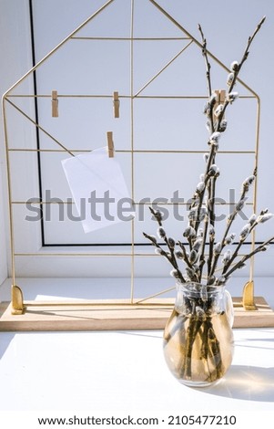 Mock up interior Picture frame with Willow branch in glass vase. Brunch of the blossoming pussywillow on early spring. Art concept. Scandinavian interior design. Easter spring still life
