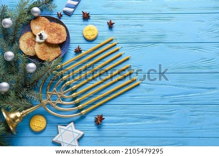 Symbols of Hanukkah and Christmas decor on color wooden background