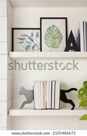 Bookends and other decor on shelves indoors. Interior design