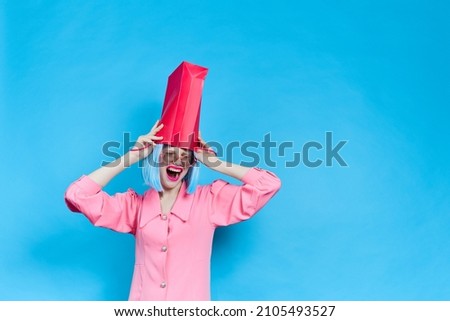 woman in pink dress with red package on her head studio