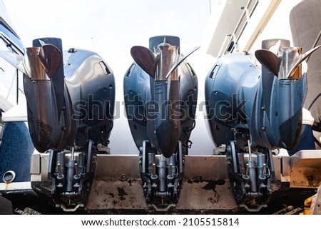 Three outboard motors mounted on the stern of a motor boat, bottom view. Royalty-Free Stock Photo #2105515814