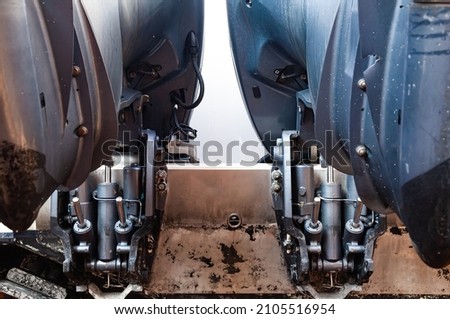 Lifting mechanisms on outboard motors at the stern of the boat. Transom lift on outboard motors of a motor boat. Royalty-Free Stock Photo #2105516954