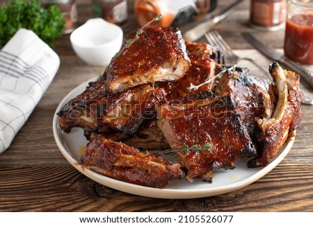 Honey glazed barbecue ribs or spareribs on wooden table Royalty-Free Stock Photo #2105526077