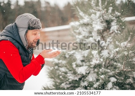Man is happy like child with snow in hand, real fun for adult, winter holiday. People have fun on winter holiday, freedom