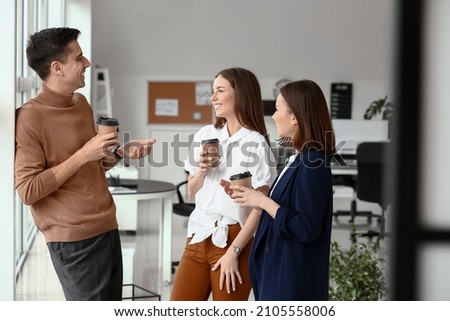 Business colleagues drinking coffee in office Royalty-Free Stock Photo #2105558006