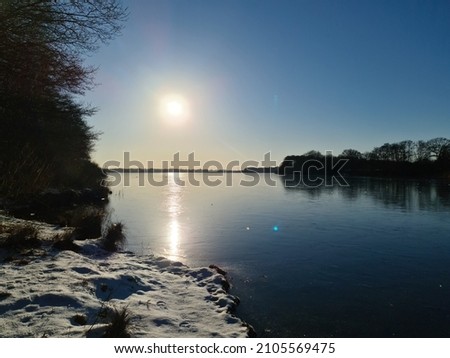 View over frozen lake with reflection of blue sky in clear weather