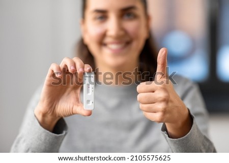 medicine, quarantine and pandemic concept - close up of happy smiling woman holding negative self testing coronavirus test