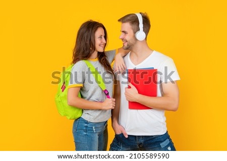 guy and girl hold notebook. university students on yellow background. study with workbook.