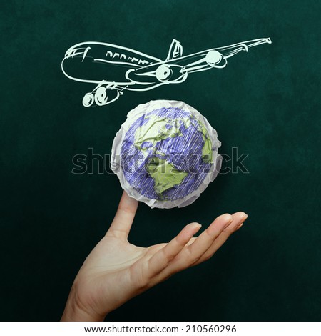 hand showing airplane with crumpled world paper symbol as concept on blackboard