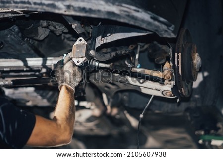 car suspension diagnostics, auto mechanic touches suspension arms and silent blocks Royalty-Free Stock Photo #2105607938