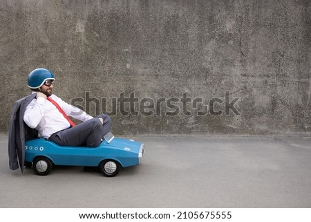 Portrait of funny businessman outdoor. Man driving retro pedal car. Back to work, start up and business idea concept Royalty-Free Stock Photo #2105675555