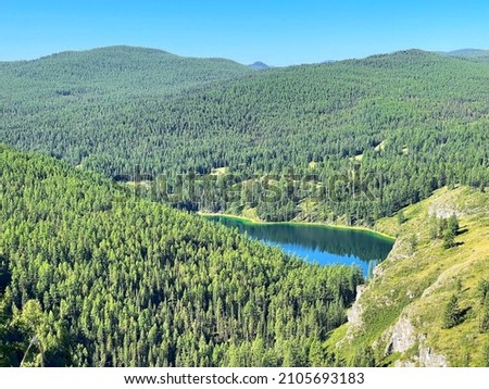 Mountain lake with emerald water surrounded by dense forest