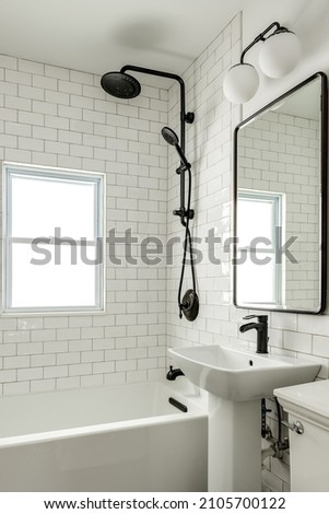 Vintage White Bathroom with Pedestal Sink and Subway Tile and Black Matte Fixtures Royalty-Free Stock Photo #2105700122