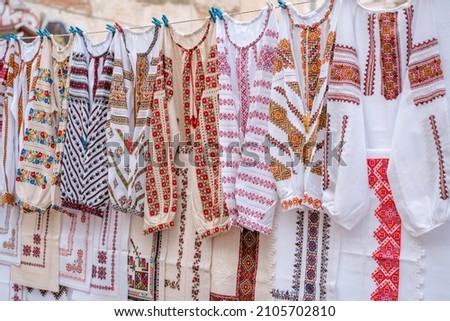 Different Ukrainian vintage clothes - traditional embroidered shirts, vyshyvanka. Traditional ukrainian dresses on flea market Vernissage in Lviv, thrift shopping concept. Selective focus Royalty-Free Stock Photo #2105702810