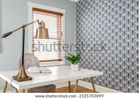 Vintage Home Office with Gold Desk Lamp and Bold Geometric Wallpaper Royalty-Free Stock Photo #2105703899