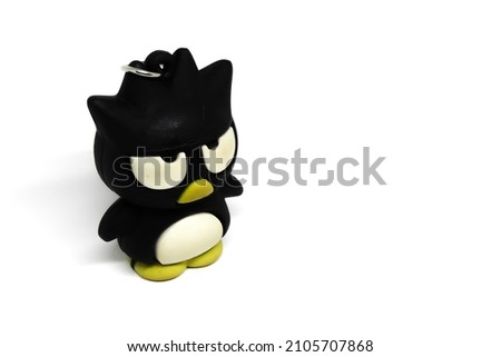black penguin miniature for keychain with angry expression, macro photo, isolated photo