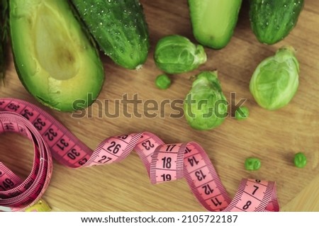 Pink tape measure and green vegetables diet concept . High quality photo