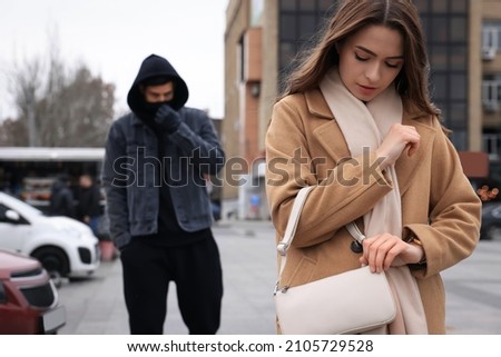 Man stalking young woman on city street Royalty-Free Stock Photo #2105729528