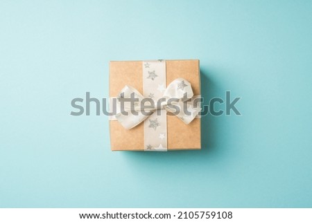 Top view photo of valentine's day decorations craft paper giftbox with white ribbon bow star pattern on isolated pastel blue background with copyspace