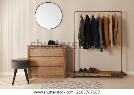 Modern dressing room interior with stylish clothes, shoes and mirror Royalty-Free Stock Photo #2105767187