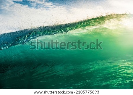 Surfing wave in Atlantic ocean with sunshine. Glassy turquoise wave sunny day